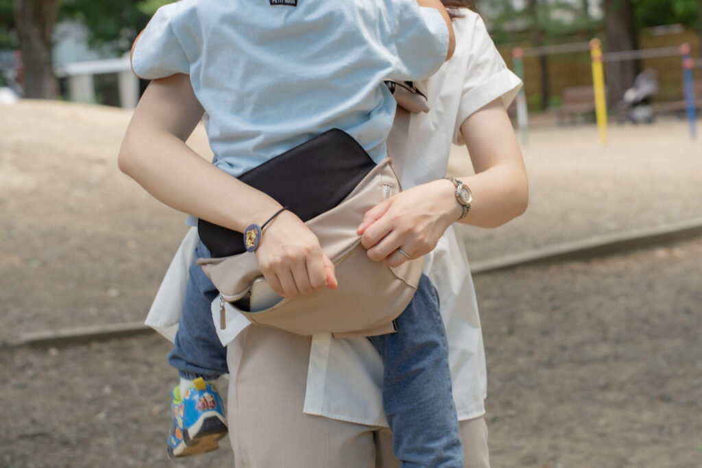 抱っこして携帯を取り出す写真